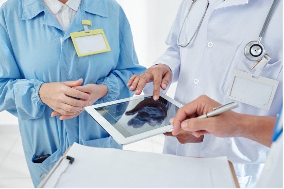 Physicians with electronic tablet and clipboard