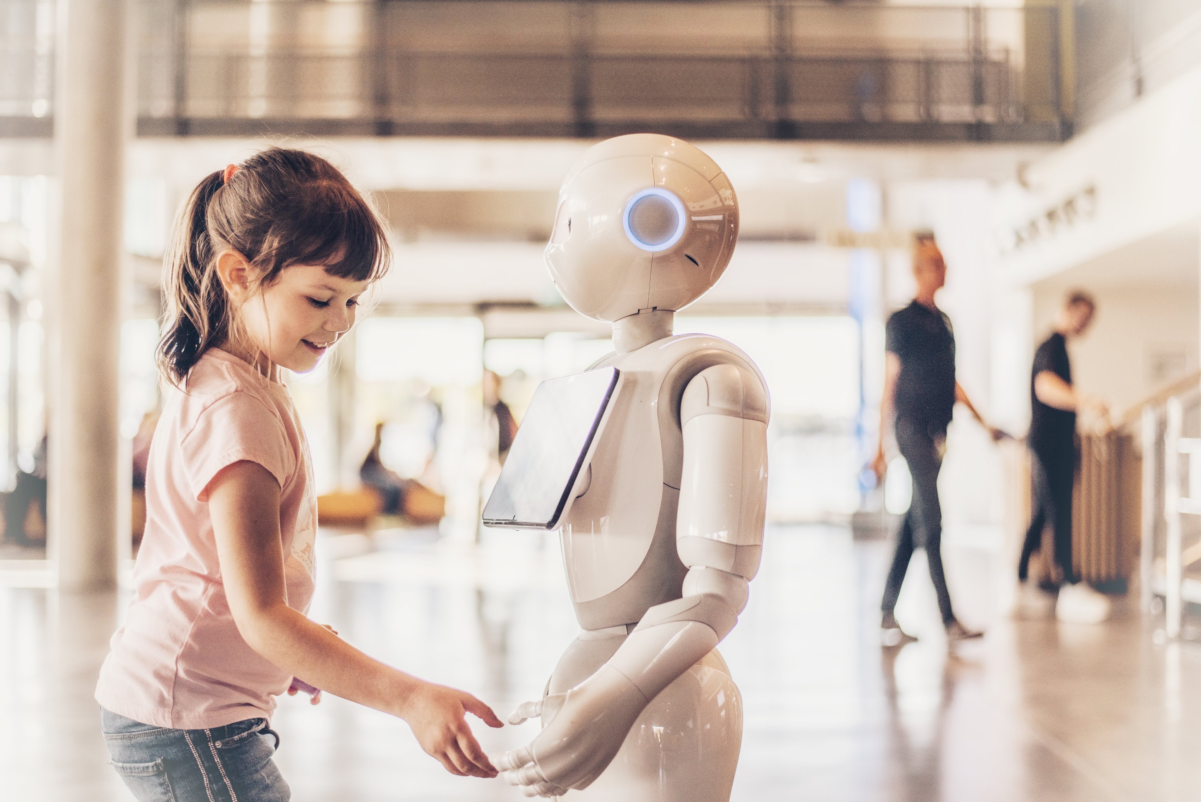 Girl interacting with a robot (source: Envato Elements)