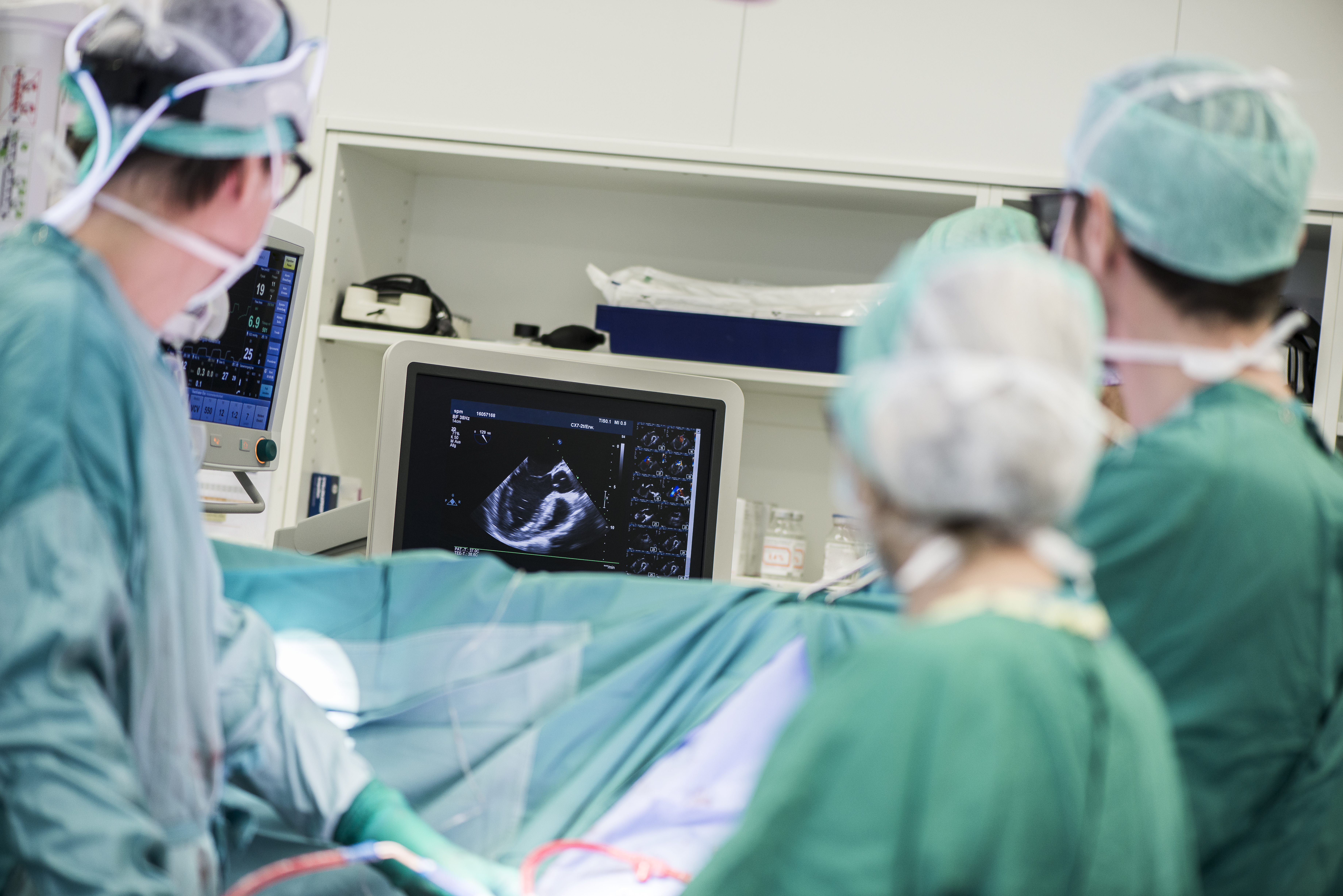 Heart surgeons looking at a heart ultrasound. (Source: Envato)
