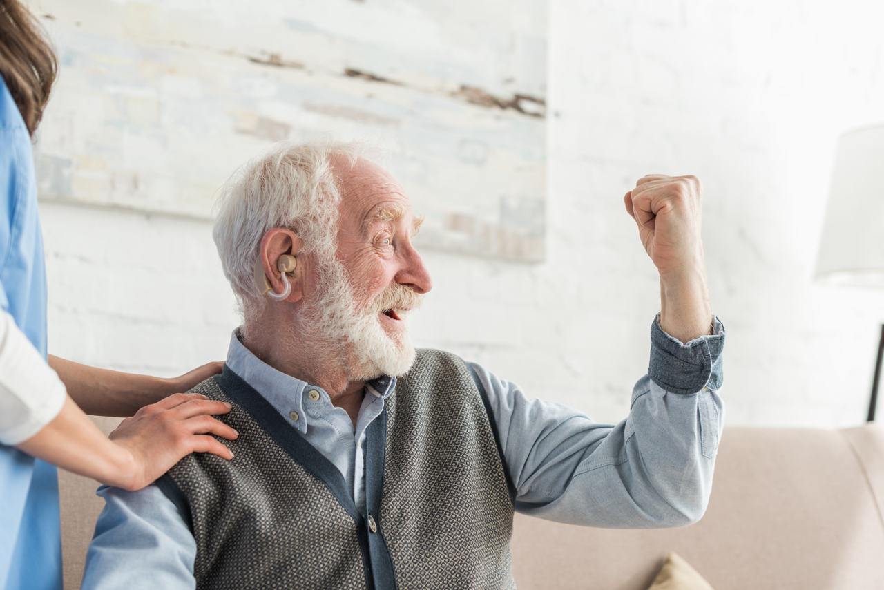 Happy man with hearing aid (source: Envato)